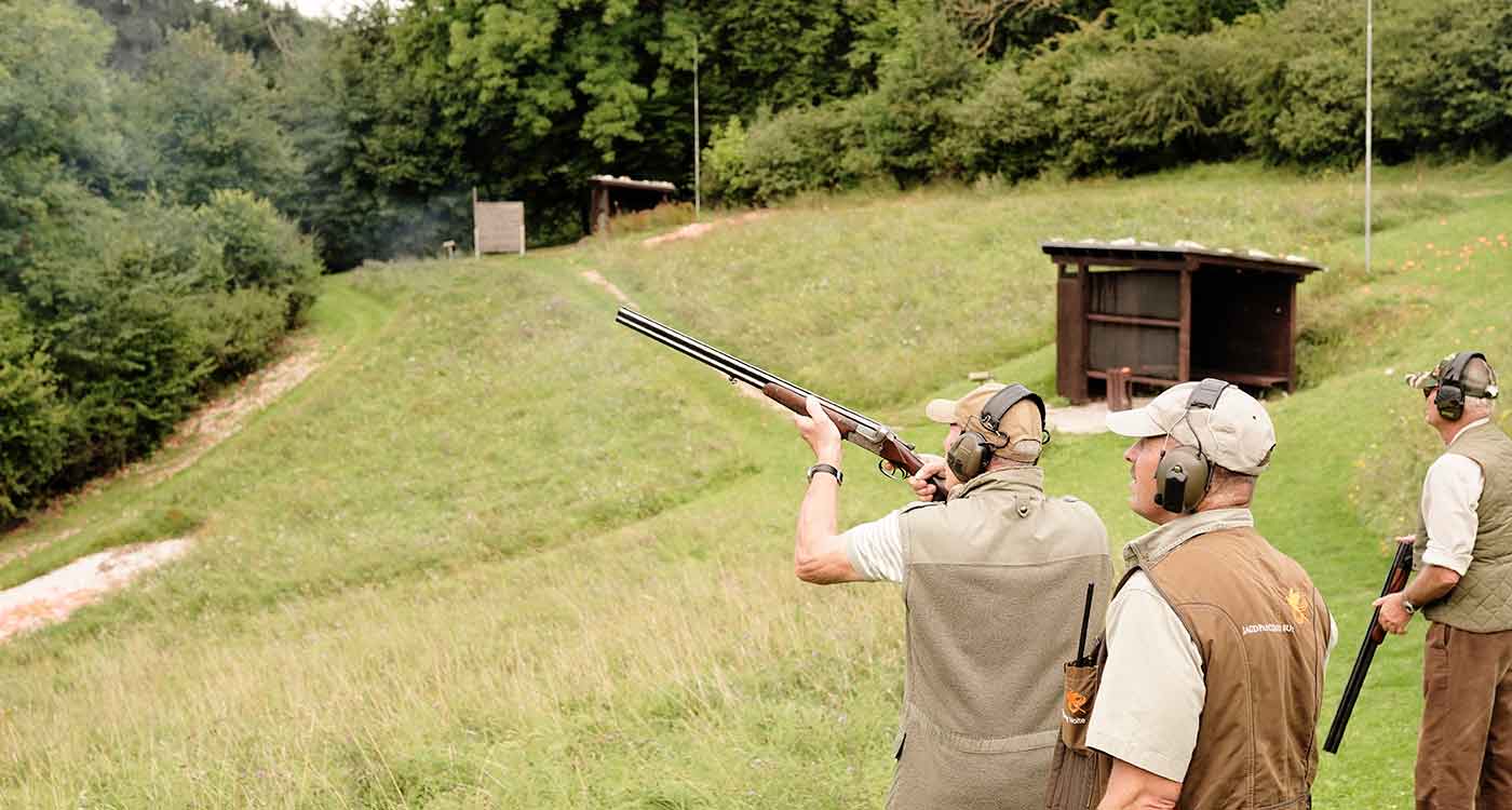 Eine Gruppe Herren schießt auf Tontauben