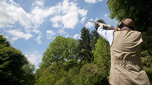 Ein Jaeger mit Gewehr auf dem Jagdparcours Buke